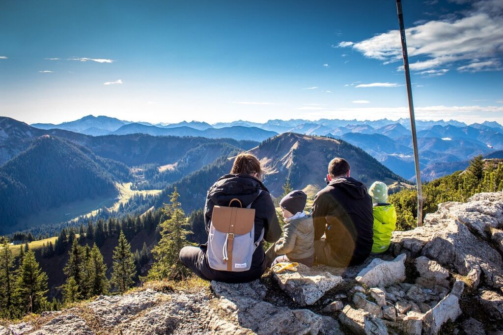 family sitting atop a mountain