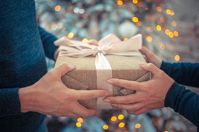 person giving a gift to another