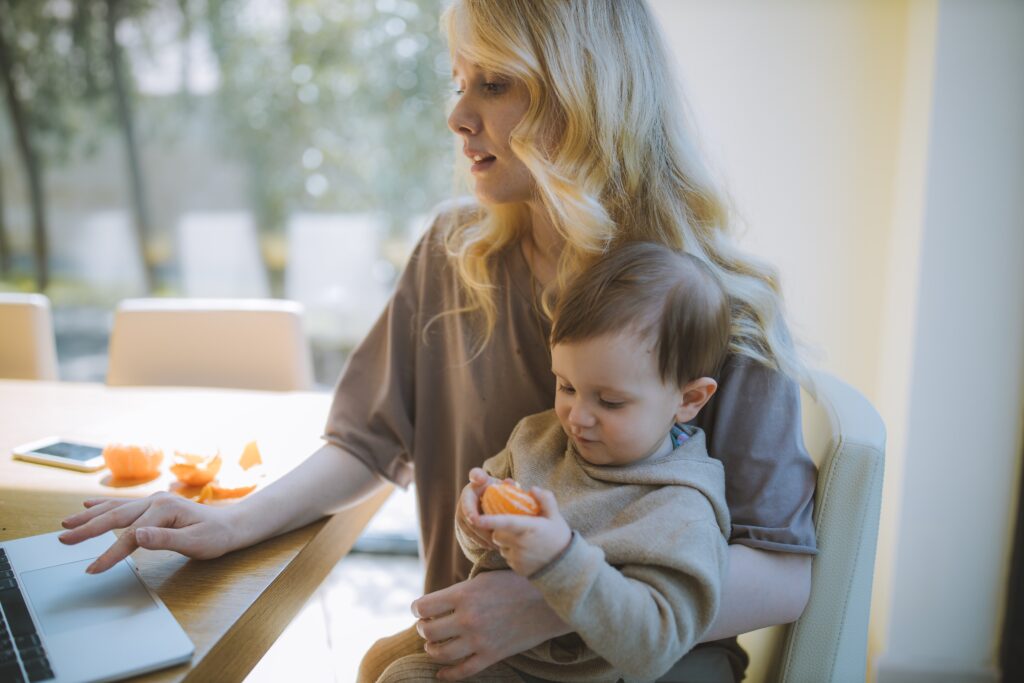 mother sitting at desk and holding baby