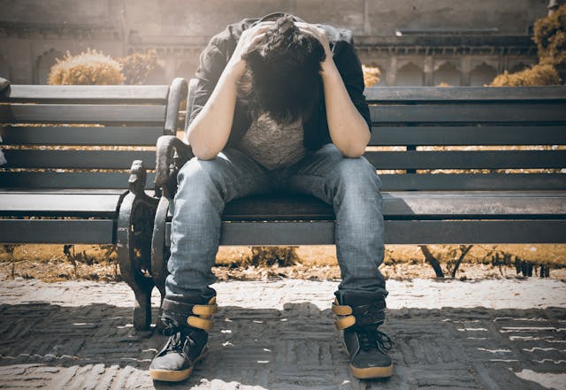 boy holding head and sitting